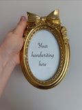 Gold oval frame with bow - 6 x 4 inch opening